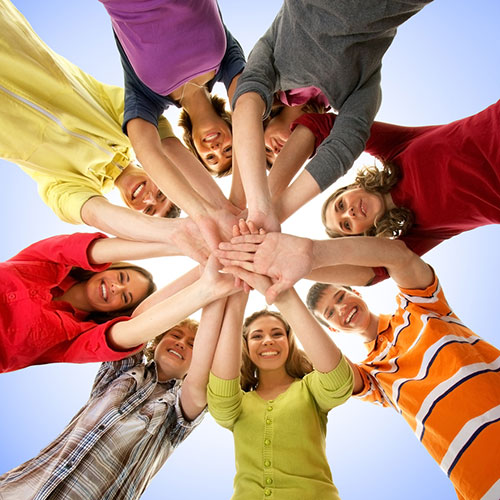 Circle of 8 people putting their hands together in the center
